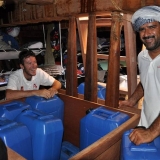090   Adam Al Baluchi and Alessandro Ghidoni moving jerrycans