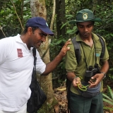 086   Ahmed Al Balushi inspects a moderately venomous green whip snake held by conservationist & guide, Mr. Vishan