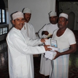 115   Captain Saleh Al Jabri presents copies of the Holy Koran to the muezzin of the Al Khairat Mosque