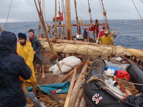 With sails down, the crew waits out the storm